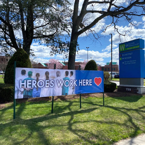 large lawn sign outside of a hospital that reads "heroes work here"