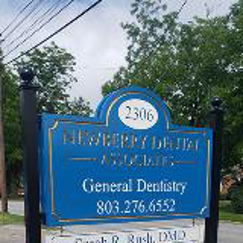 New berry dental Associates signage  on the side of the road with wires and trees on the background