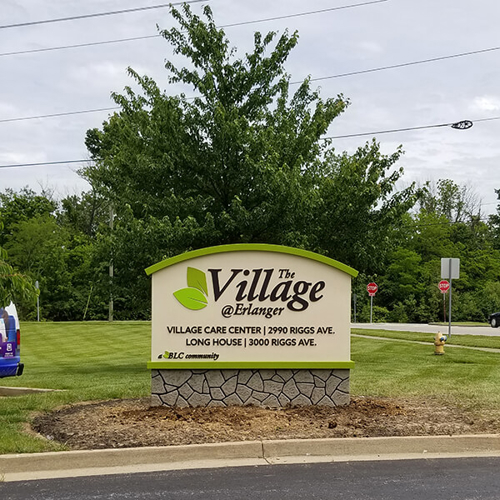 Green and white the village monument signage