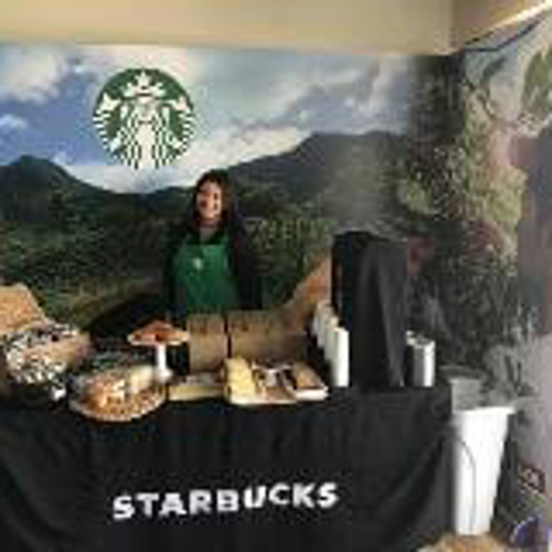 Starbucks banner and products with a Starbucks employee