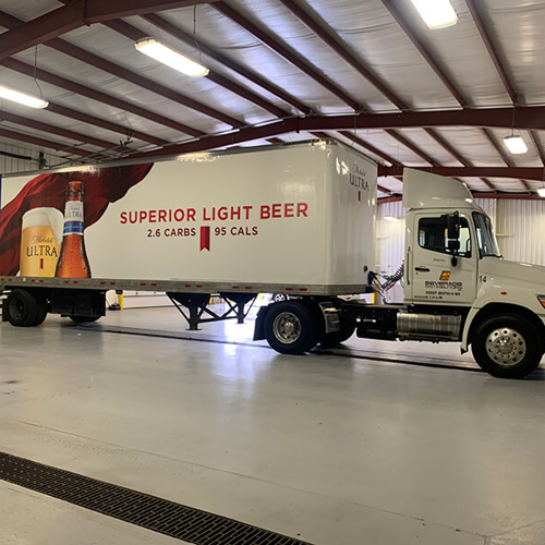 Superior light beer truck wrapped with graphics and parked on a garage