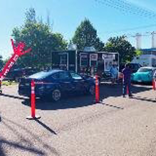 Cars on the drive-thru line with trailer truck and people