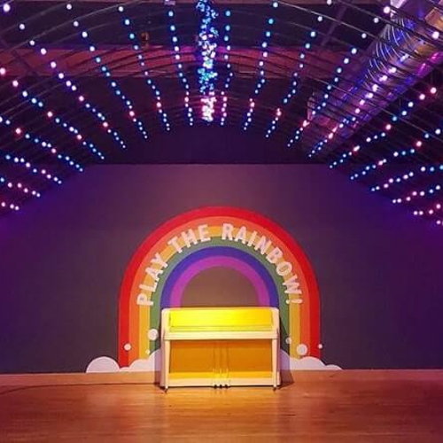 Rainbow graphics on the stage with lights and piano