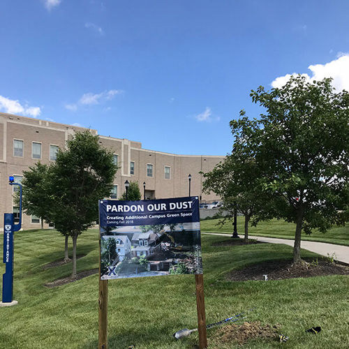 Custom signage in the field with building background