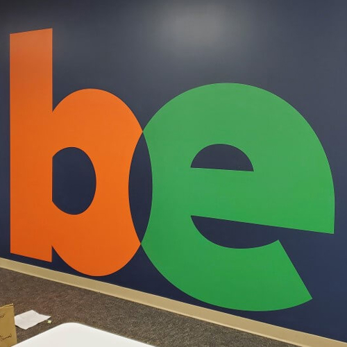 Be custom decal on a colorful wall