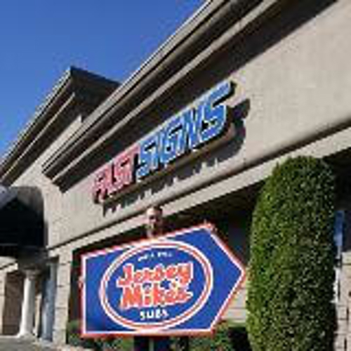 Man holding as Jersey Mikes signage in front of the fast sign office