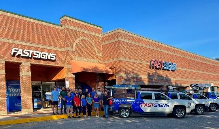 fastsigns building exterior with team standing in front