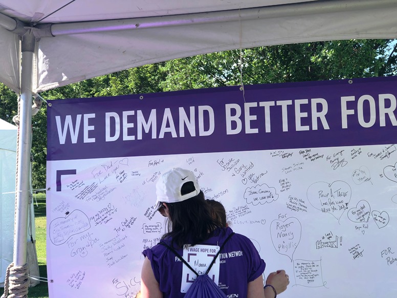 a "We Demand Better' banner for the Purple Stride walk