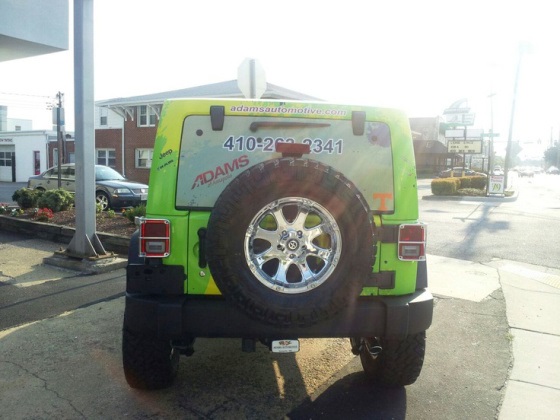 a car is wrapped in graphics for adams of annapolis