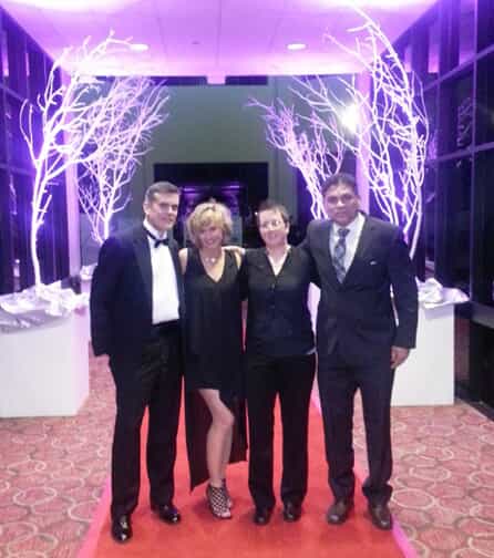 a fastsigns team poses together on a red carpet