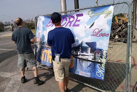 a bmore strong sign is hung on a fence
